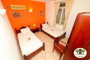 two beds in a room with orange walls at Cheerful 2-bedroom Villa with a pool at Malindi in Malindi