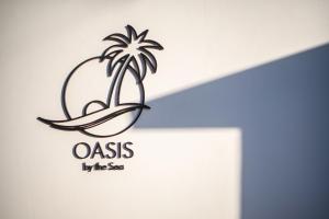 拉納卡的住宿－Oasis By The Sea - Cyprus，棕榈树海滩度假村的标志