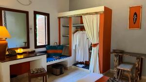 Habitación con vestidor, espejo y mesa. en Pinewood Beach Resort and Spa en Diani Beach