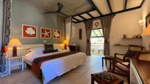 una camera con un letto e una sedia di Pinewood Beach Resort and Spa a Diani Beach