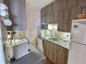una cucina con un frigorifero bianco e un lavello di Vue mer à la plage du Môle - Clim - Fibre Wifi a Cap d'Agde