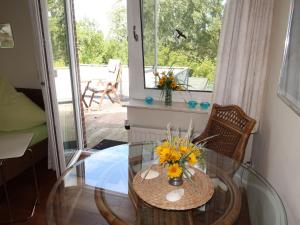 a glass table with flowers on it in a room at Apartment Landhaus Mahnhamm-1 by Interhome in Wiarden