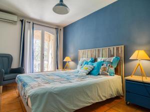 PignansにあるHoliday Home Cros de Gourdin by Interhomeの青い壁のベッドルーム1室(大型ベッド1台付)