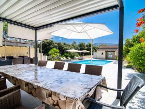 een patio met een tafel, een parasol en een zwembad bij Holiday Home Cros de Gourdin by Interhome in Pignans