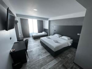a hotel room with two beds and a flat screen tv at Motel SUPER SAN in Posušje