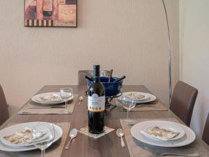 a table with a bottle of wine and plates of food at Apartment Rosablanche C61 by Interhome in Siviez