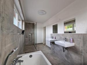 uma casa de banho com 2 lavatórios e uma banheira em RAJ Living - 4 Room Apartments - 30 Min Messe DUS em Neuss