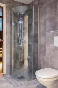 a bathroom with a shower and a toilet at GLØD Boutique Apartment in Alta