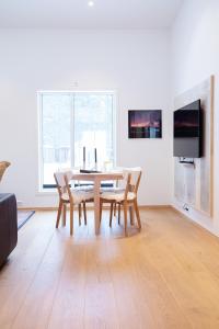 a dining room with a table and chairs and a tv at GLØD Boutique Apartment in Alta