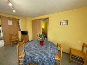 un comedor con una mesa con una maceta. en Apartment Résidence jaune et rose-1 by Interhome en Marckolsheim