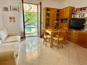 un soggiorno con un tavolo e una TV di Holiday Home Romina - DMA175 by Interhome a Domaso