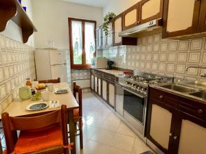 una cucina con tavolo, lavandino e frigorifero di Holiday Home Romina - DMA175 by Interhome a Domaso Altre 20 foto