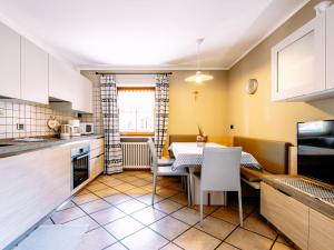een keuken en eetkamer met een tafel en stoelen bij Apartment Carmen-3 by Interhome in Soraga