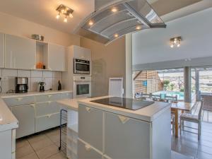 a kitchen with white cabinets and a large window at Holiday Home Les Baïnes - VIB220 by Interhome in Vieux-Boucau-les-Bains