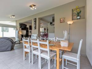 a dining room and living room with a table and chairs at Holiday Home Les Baïnes - VIB220 by Interhome in Vieux-Boucau-les-Bains