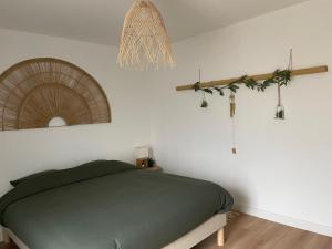 una camera con letto verde e specchio di Le Clos des Glycines a Saint-Martin-lez-Tatinghem