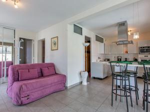 Una sala de estar con un sofá morado y una cocina. en Holiday Home Les Baïnes by Interhome, en Vieux-Boucau-les-Bains