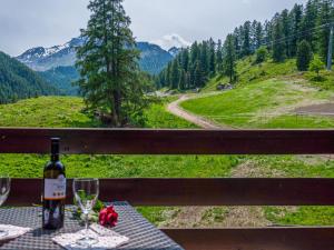eine Flasche Wein auf einem Tisch mit Weingläsern in der Unterkunft Apartment Mont Fort 43 by Interhome in Siviez