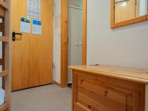 Zimmer mit einer Holztür und einem Schreibtisch aus Holz in der Unterkunft Apartment Mont Fort 43 by Interhome in Siviez