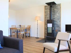 ein Wohnzimmer mit einem Kamin, einem Tisch und Stühlen in der Unterkunft Apartment Meribel 1 by Interhome in Villars-sur-Ollon