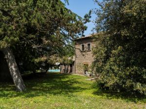 ein Steingebäude in einem Hof mit einem Baum in der Unterkunft Apartment La Capraccia-5 by Interhome in Bagnoregio