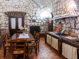 eine Küche mit einem Tisch und einem Herd im Zimmer in der Unterkunft Apartment La Capraccia-5 by Interhome in Bagnoregio