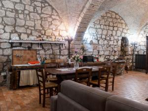 a dining room with a table and a stone wall at Apartment La Capraccia-5 by Interhome in Bagnoregio