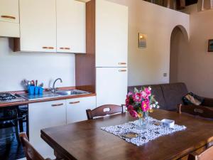 eine Küche mit einem Tisch und einer Blumenvase darauf in der Unterkunft Apartment La Capraccia-7 by Interhome in Bagnoregio