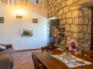 ein Wohnzimmer mit einem Tisch und einer Steinmauer in der Unterkunft Apartment La Capraccia-7 by Interhome in Bagnoregio