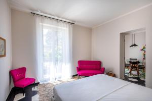 a bedroom with two pink chairs and a bed at Normanni Apartment with Terrace by Wonderful Italy in Palermo