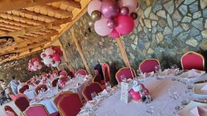 a banquet hall with white tables and pink balloons at Doka Valea Sebesului A-Frame in Sebeşu
