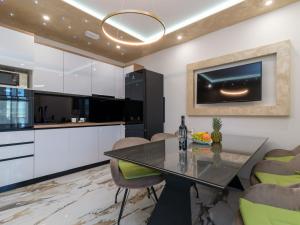 a kitchen with a dining table and a tv on the wall at Apartment Mornar-3 by Interhome in Trogir