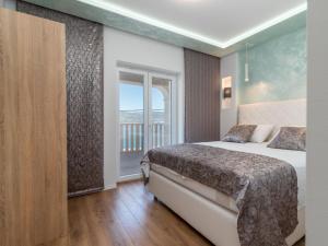 a hotel room with a bed and a balcony at Apartment Mornar-3 by Interhome in Trogir