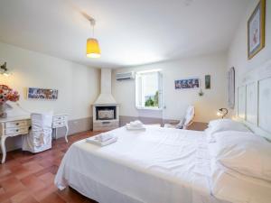 - une chambre avec un grand lit blanc et un bureau dans l'établissement Villa Casale dei tigli by Interhome, à San Feliciano