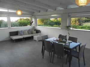 un soggiorno con tavolo, sedie e divano di Resort Pietra Bianca a Noci