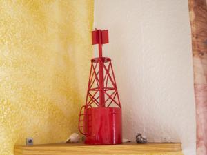 ノルトダイヒにあるApartment Am Koper Sand-2 by Interhomeの棚上に座る赤花瓶
