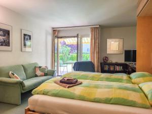 sypialnia z łóżkiem i kanapą w obiekcie Apartment Parcolago - Utoring-29 by Interhome w mieście Caslano