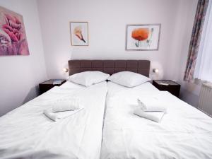 ein großes weißes Bett mit zwei weißen Kissen darauf in der Unterkunft Apartment Borkum by Interhome in Norddeich