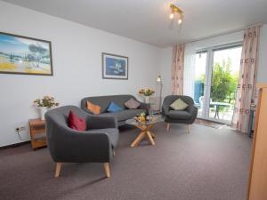 ein Wohnzimmer mit 2 Stühlen, einem Sofa und einem Tisch in der Unterkunft Apartment Borkum by Interhome in Norddeich