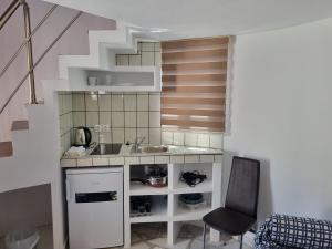 a small kitchen with a sink and a staircase at Panorama Studios in Faliraki