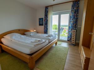 a bedroom with two beds and a large window at Holiday Home Uhu by Interhome in Dittishausen
