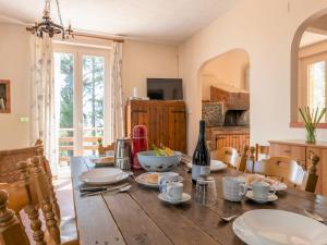 uma sala de jantar com uma mesa de madeira com pratos em Villa Mareneve by Interhome em Linguaglossa