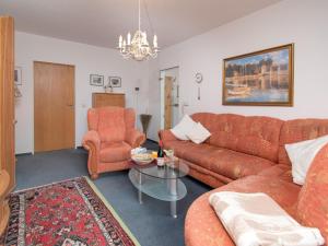 ein Wohnzimmer mit einem Sofa, einem Tisch und Stühlen in der Unterkunft Apartment Baltrum-Badestrasse by Interhome in Norddeich