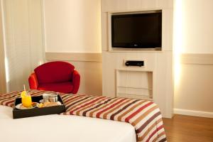 a hotel room with a bed and a television at Mercure Brasilia Lider in Brasília