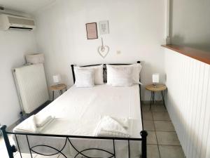 アルゴストリオンにあるMaistrato Apartmentsのベッドルーム1室(白いベッド1台、テーブル2台付)