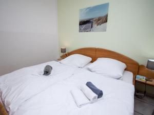 ein weißes Bett mit Schuhen und Handtüchern darauf in der Unterkunft Apartment Seestern by Interhome in Norddeich