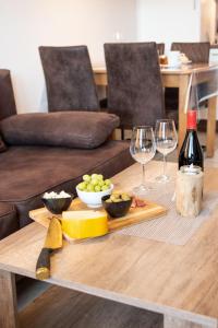 einen Tisch mit zwei Gläsern Wein und ein Tablett mit Essen in der Unterkunft Apartment Seestern by Interhome in Norddeich