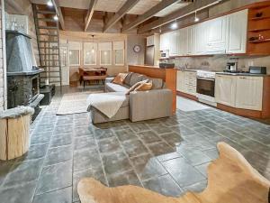 ein großes Wohnzimmer mit einem Sofa und einer Küche in der Unterkunft Holiday Home Rukan taikavuosselin helmi 8 b by Interhome in Ruka