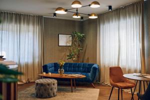 a living room with a blue couch and a table at Hotel Republika in Zagreb