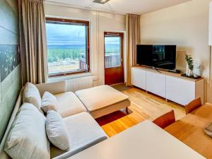 a living room with a couch and a flat screen tv at Holiday Home Ski chalets 6203- during winter season 2 by Interhome in Ylläs